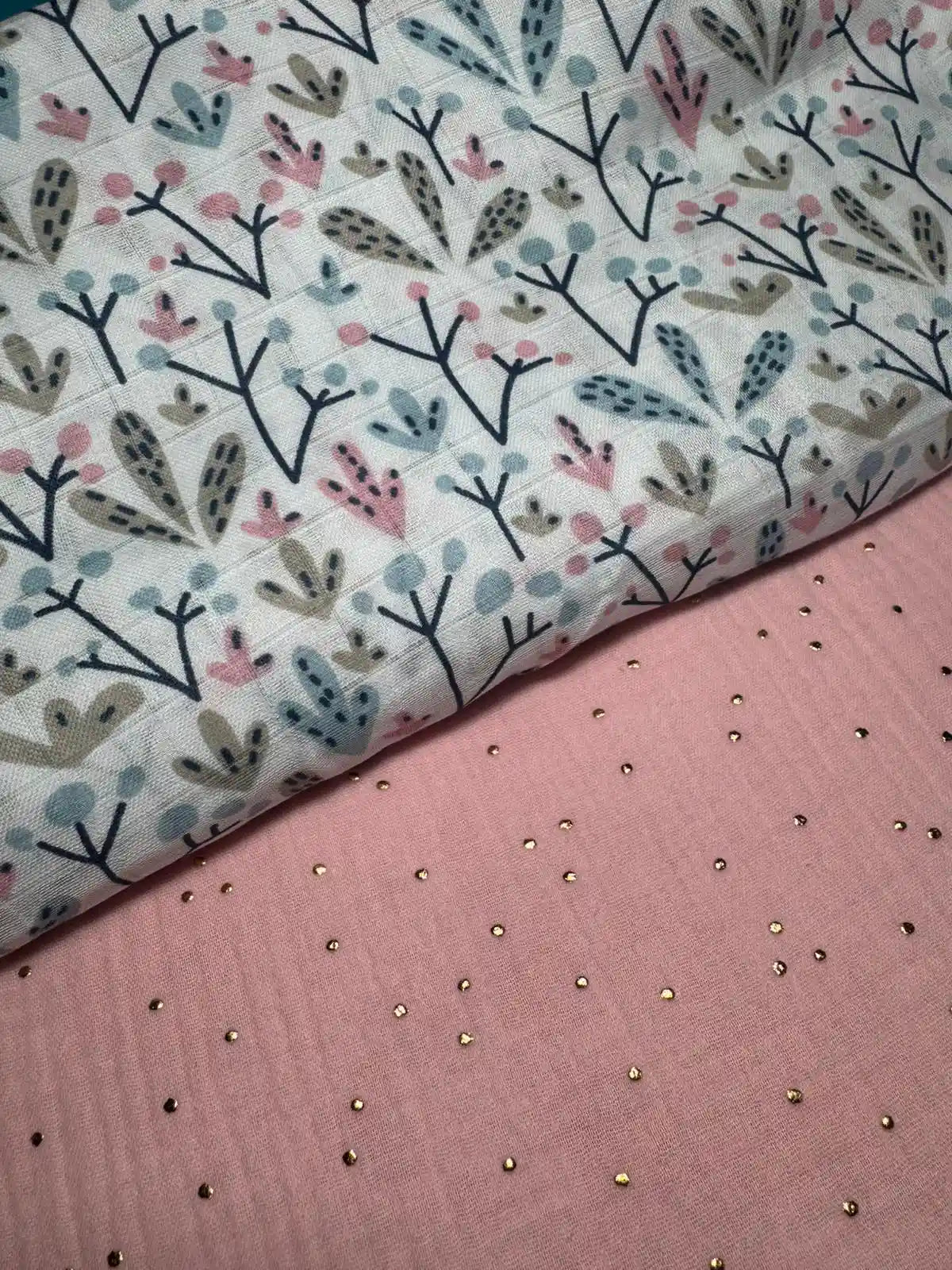 Tela de muselina rosa con lunares dorados 